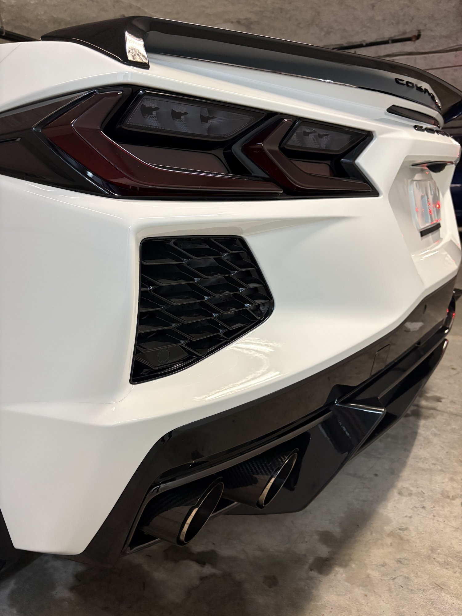 Corvette C8 rear exterior detail — exhaust tips and taillight close-up after polish