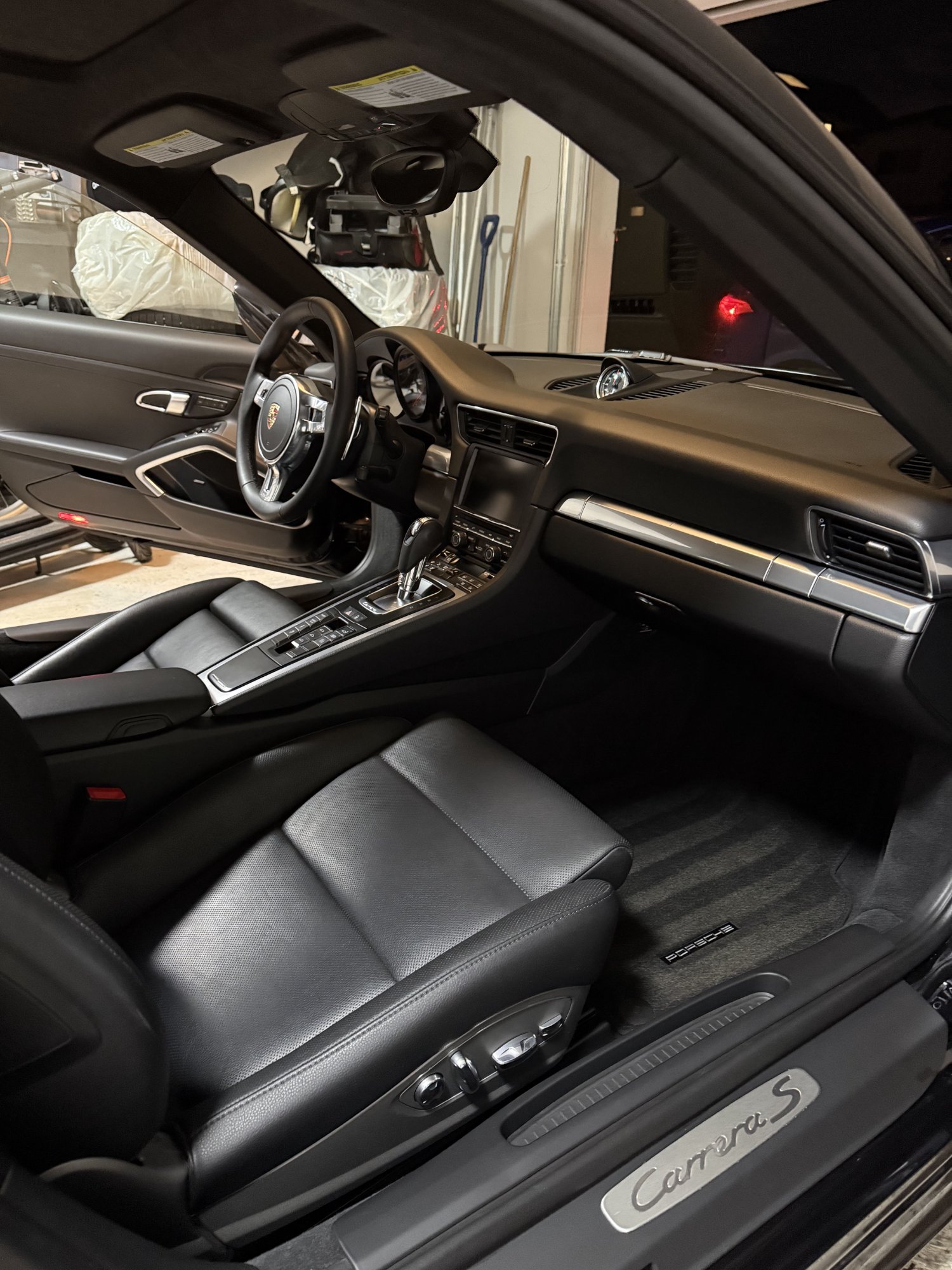 Porsche 911 Carrera S interior detail — black leather seats and dashboard cleaned